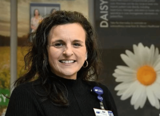 female, brown hair, black top, daisy wall
