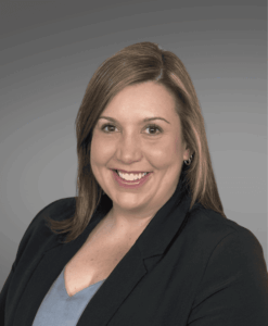 female, brown hair, black jacket, gray top